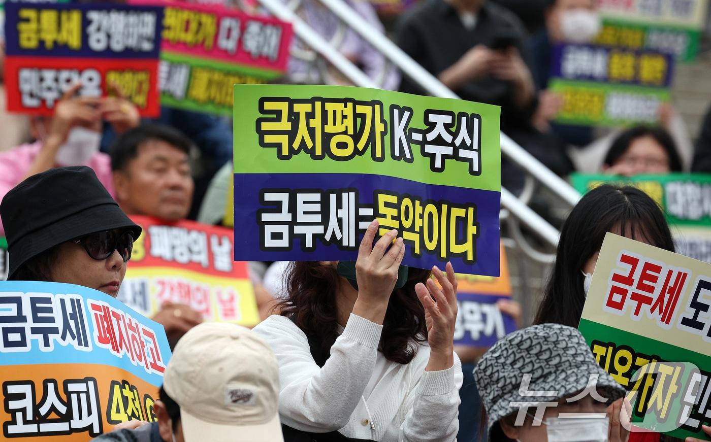 한국주식투자자연합회 회원 및 개인투자자들이 21일 오후 서울 중구 서울역 광장에서 금융투자소득세 도입을 반대하는 피켓을 들어보이고 있다. 2024.9.21/뉴스1 ⓒ News1 장수영 기자