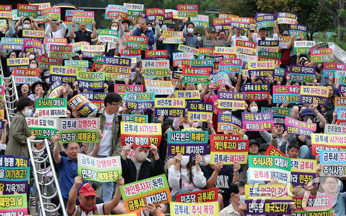 한국주식투자자연합회 회원 및 개인투자자들이 21일 오후 서울 중구 서울역 광장에서 금융투자소득세 도입을 반대하는 피켓을 들어보이고 있다. 2024.9.21/뉴스1 ⓒ News1 장수영 기자