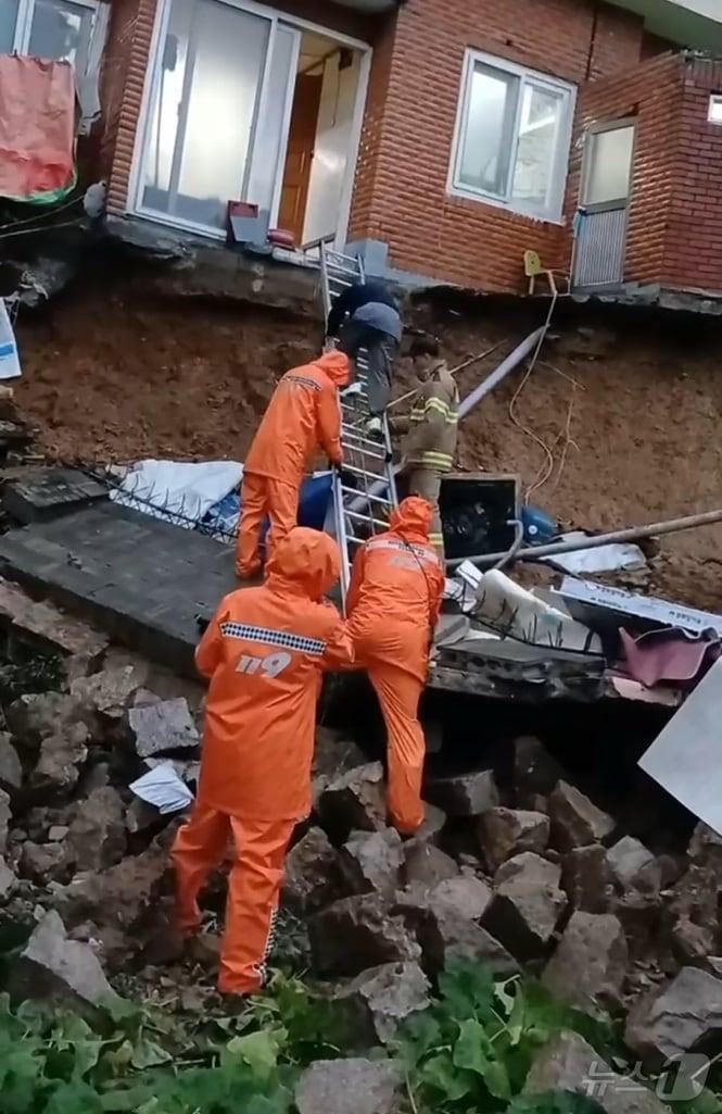 21일 부산진구 연지동 한 주택 담벼락이 무너지면서 2명이 고립돼 소방대원이 구조하고 있다.&#40;부산소방재난본부 제공&#41;