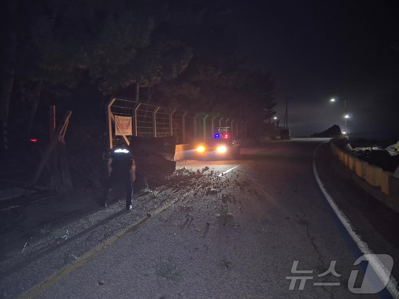 지난 19일 오후 9시10분쯤 고성 백삼해안도로 안전펜스에 3톤 가량의 낙석과 토사 등을 발견한 고성 금강파출소 박상민 경사&#40;36&#41;와 박종웅 경감&#40;52&#41;이 순찰차로 도로 통제에 나서고 있다.&#40;강원경찰청 제공&#41;/뉴스1