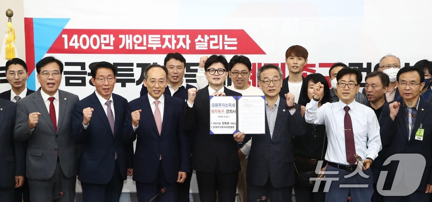 한동훈 국민의힘 대표와 추경호 원내대표, 정의정 한국주식투자자연합회 대표 및 개인투자자들이 24일 오전 서울 여의도 국회에서 열린 1400만 개인투자자 살리는 금융투자소득세 폐지 촉구 건의서 전달식에서 기념촬영을 하고 있다. 2024.9.24/뉴스1 ⓒ News1 이광호 기자