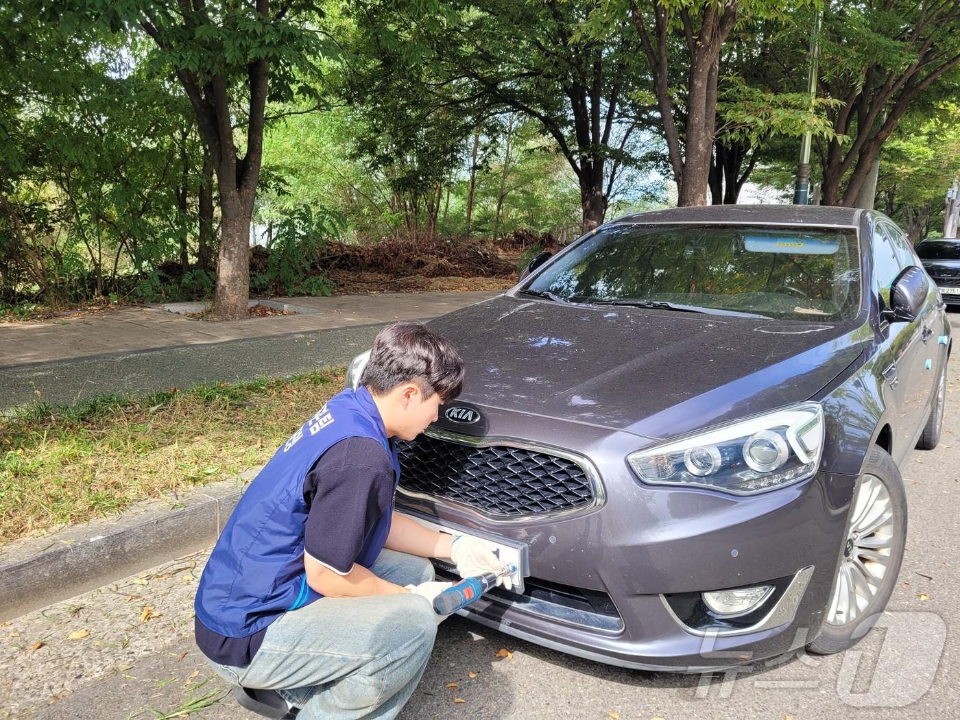 대구 달성군 직원이 체납으로 인해 차량번호판을 제거하고 있다. &#40;대구 달성군 제공&#41;