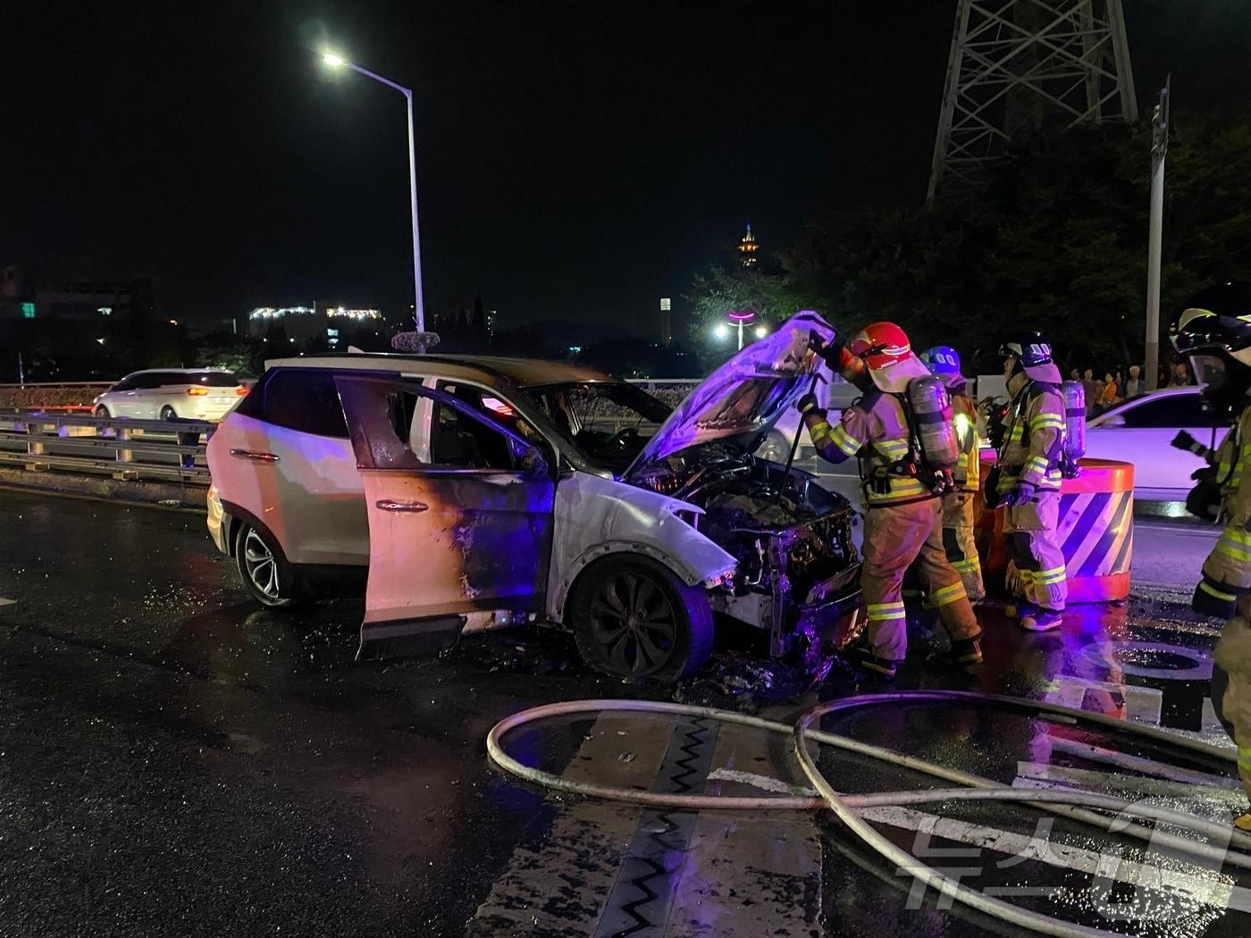 지난 26일 오후 6시 49분쯤 양산시 남부동 7번교차로에서 주행 중이던 싼타페SUV 차량에 불이 나 소방관들이 진화에 나서고 있다.&#40;경남소방본부 제공&#41;