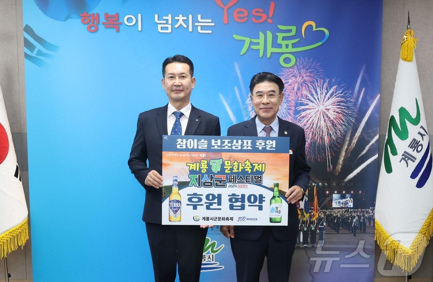 이승용 &#40;주&#41;하이트진로 특판 대전지점장&#40;왼쪽&#41;이 이응우 계룡시장과 군문화축제 홍보를 위한 ‘소주병 보조상표 후원 전달식’을 갖고 기념촬영을 하고 있다. &#40;계룡시 제공&#41; /뉴스1 