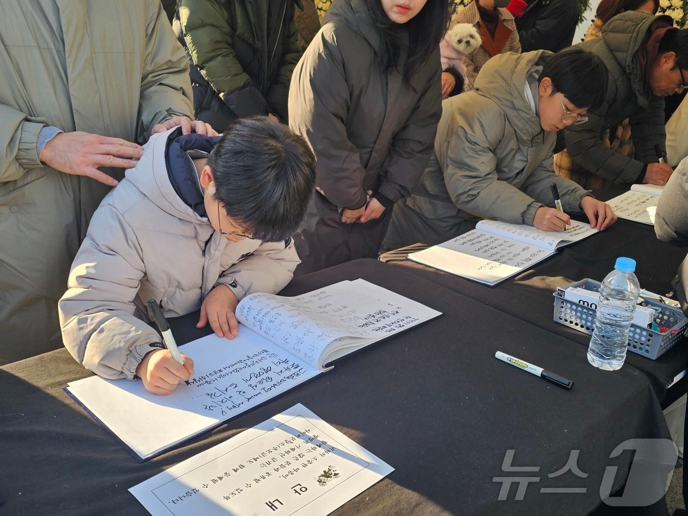 광주 동구 5·18민주광장에 마련된 제주항공 희생자 합동분향소에서 어린이들이 추모글을 적고 있다.2025.1.1./뉴스1 ⓒ News1 서충섭 기자