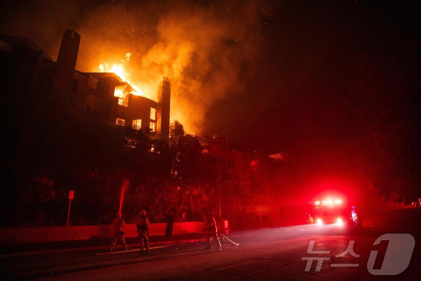 미국 LA 지역에서 발생한 대형 산불이 인근 건물에 옮겨붙고 있다.ⓒ AFP=뉴스1