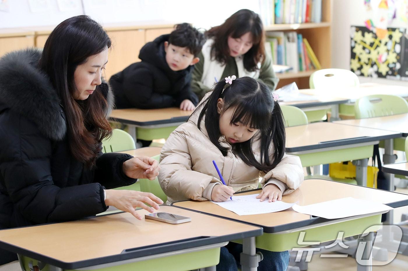 초등학교 신입생 예비소집에 참석한 어린이가 엄마와 함께 입학 서류에 이름을 적는 모습. /뉴스1 ⓒ News1 공정식 기자