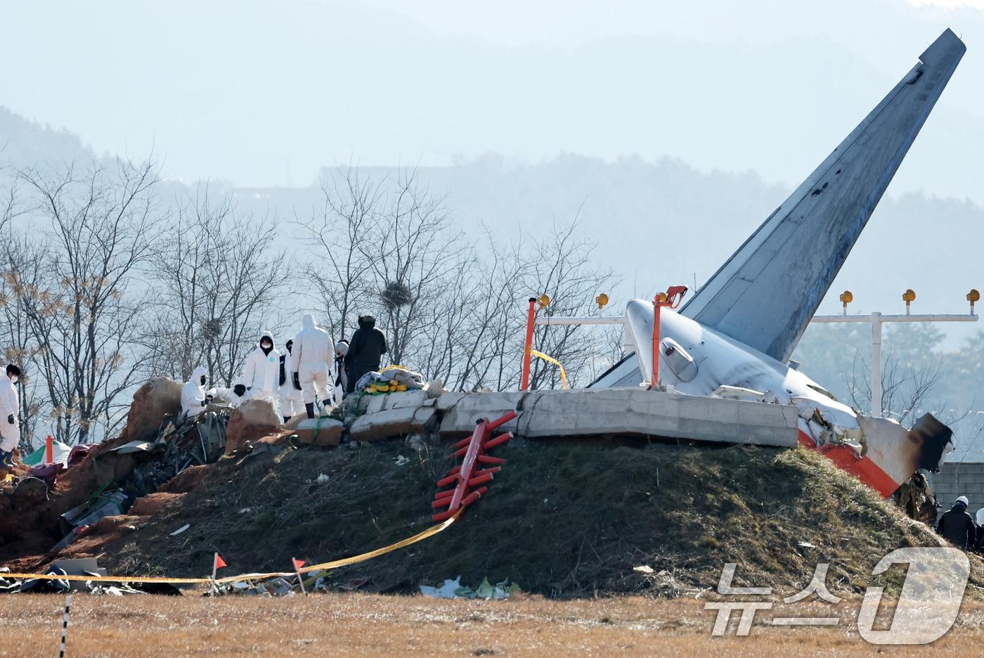 제주항공 여객기 참사 엿새째인 3일 오전 전남 무안국제공항 참사 현장에서 항공·철도사고 조사위원회&#40;ARAIB&#41; 관계자들이 로컬라이저&#40;방위각시설&#41; 둔덕에 파묻힌 엔진을 살펴보고 있다. 2025.1.3/뉴스1 ⓒ News1 오대일 기자