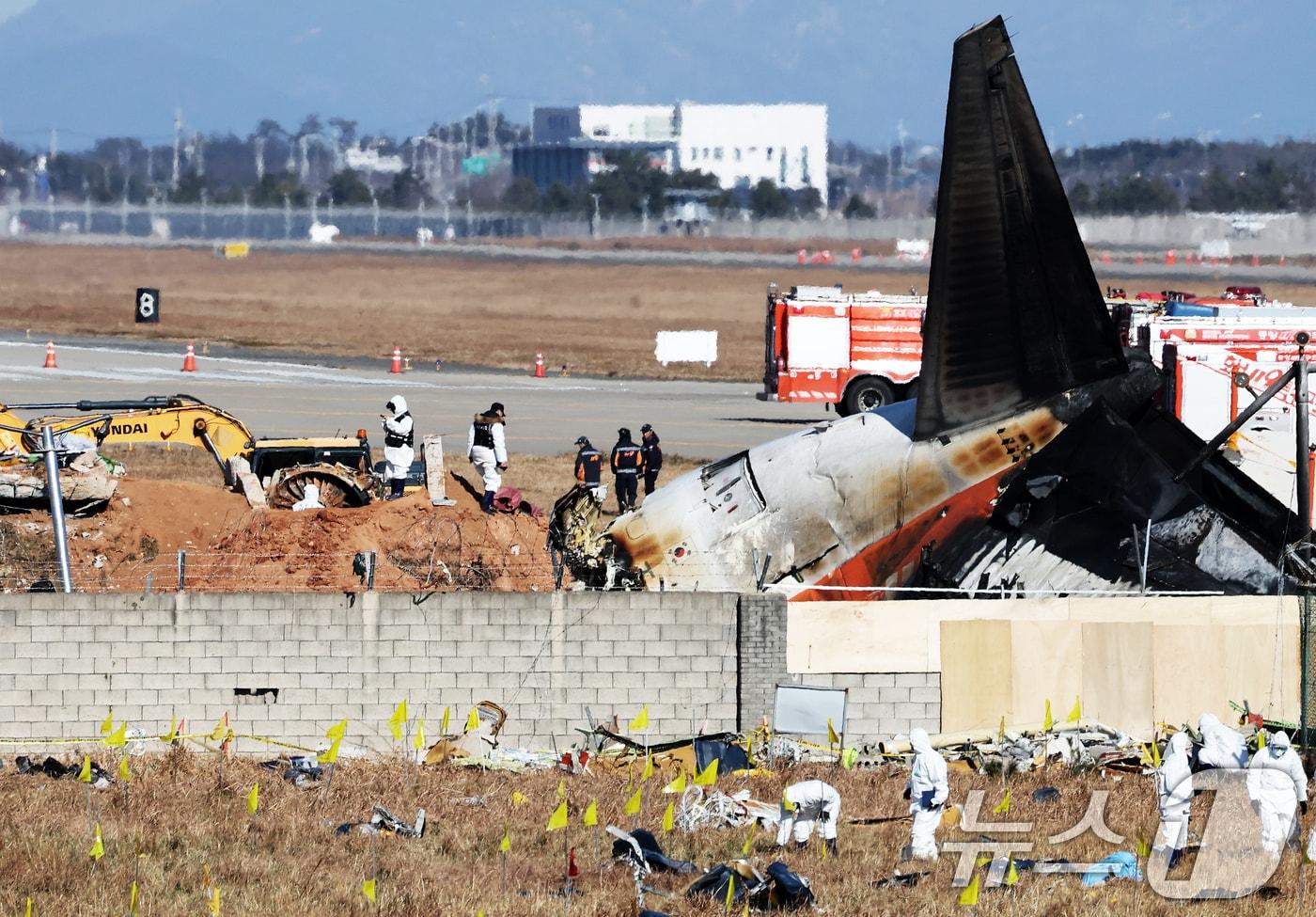 제주항공 여객기 참사 엿새째인 3일 오후 전남 무안국제공항 참사 현장에서 국과수 관계자들이 로컬라이저&#40;방위각시설&#41; 둔덕에 파묻힌 엔진을 살펴보고 있다. 2025.1.3/뉴스1 ⓒ News1 오대일 기자