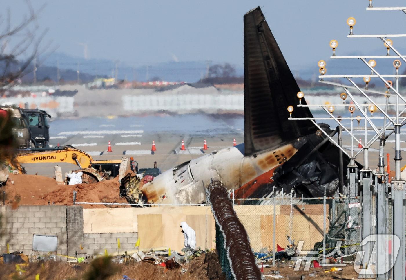 제주항공 여객기 참사 엿새째인 3일 오후 전남 무안국제공항 참사 현장에서 국과수 관계자들이 로컬라이저&#40;방위각시설&#41; 둔덕에 파묻힌 엔진을 살펴보고 있다. 2025.1.3/뉴스1 ⓒ News1 오대일 기자