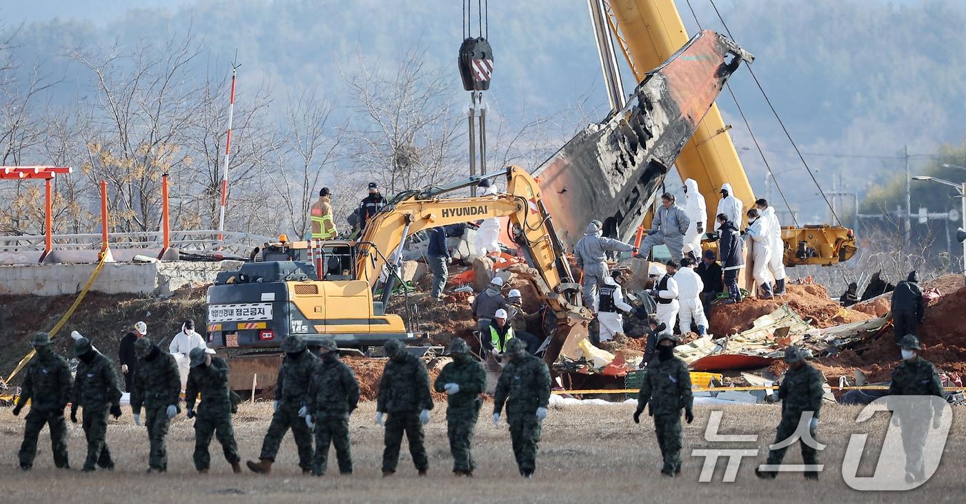 제주항공 여객기 참사 7일째인 4일 오후 전남 무안국제공항 참사 현장에서 특전사 대원들의 수색 작업 뒤로 방위각시설&#40;로컬라이저&#41;에서 엔진 인양 작업이 진행되고있다. 2025.1.4/뉴스1 ⓒ News1 김진환 기자