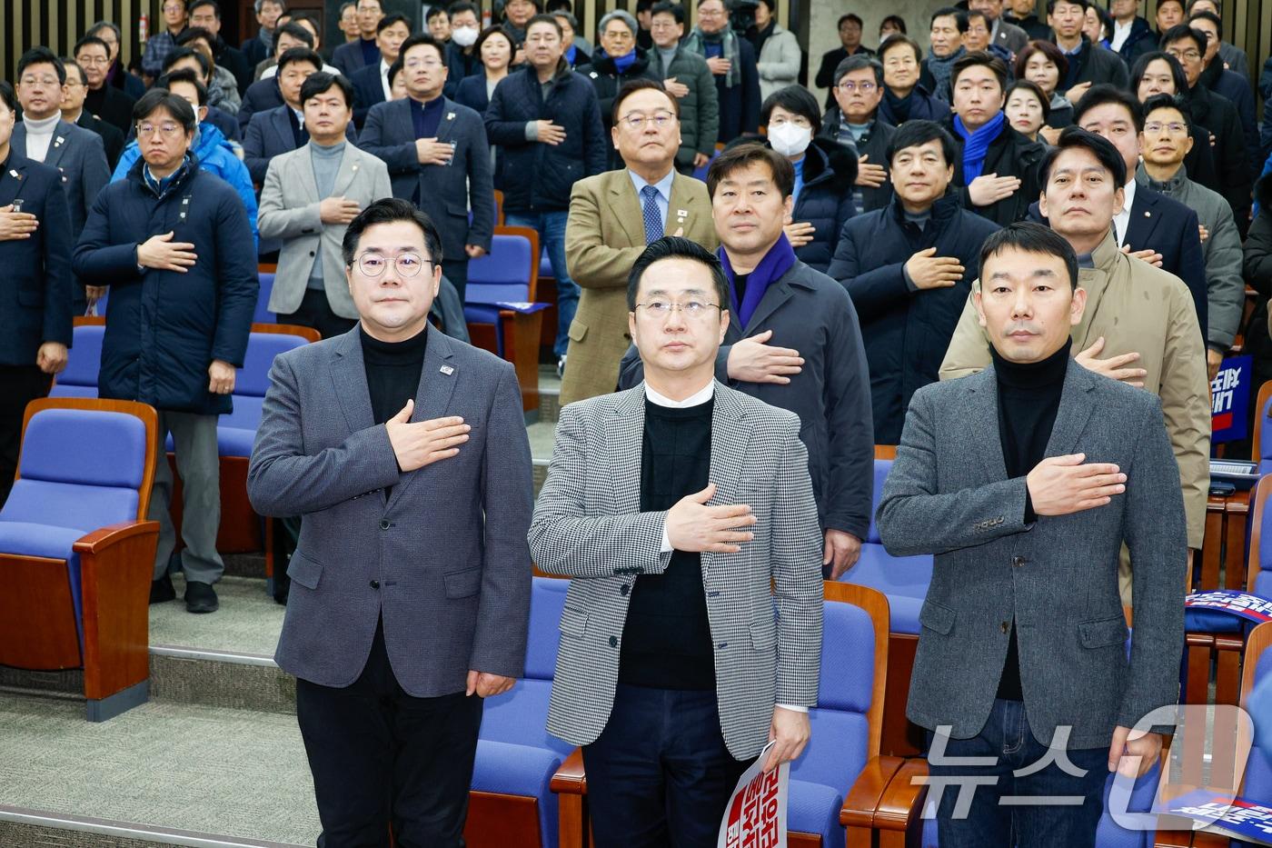 박찬대 더불어민주당 원내대표&#40;앞줄 왼쪽부터&#41;, 박성준 원내수석부대표, 김용민 원내정책수석부대표가 5일 오후 서울 여의도 국회에서 열린 비상의원총회에 참석해 국민의례를 하고 있다. 2025.1.5/뉴스1 ⓒ News1 안은나 기자