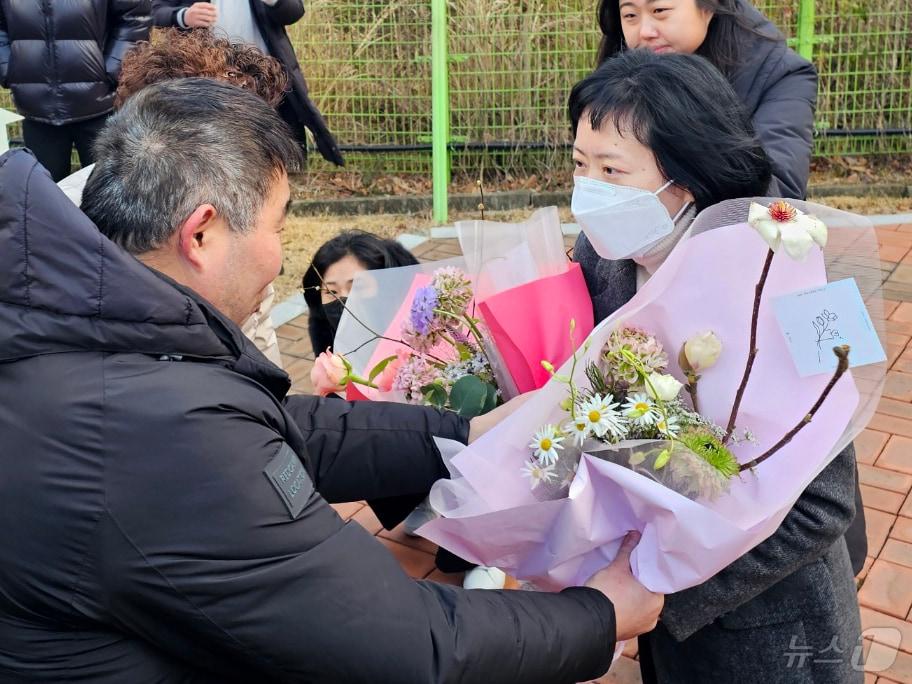 아버지를 살해한 혐의로 무기징역을 확정받은 김신혜 씨가 6일 열린 재심을 통해 24년 만에 무죄를 선고 받고 전남 장흥교도소에서 출소하고 있다. 사진은 화성 연쇄 살인사건 진범 대신 누명을 쓰고 20년간 억울한 옥살이를 하다 재심에서 무죄를 받은 피해자가 김 씨에게 꽃다발을 건네는 모습. 2024.1.6/뉴스1 ⓒ News1 최성국 기자