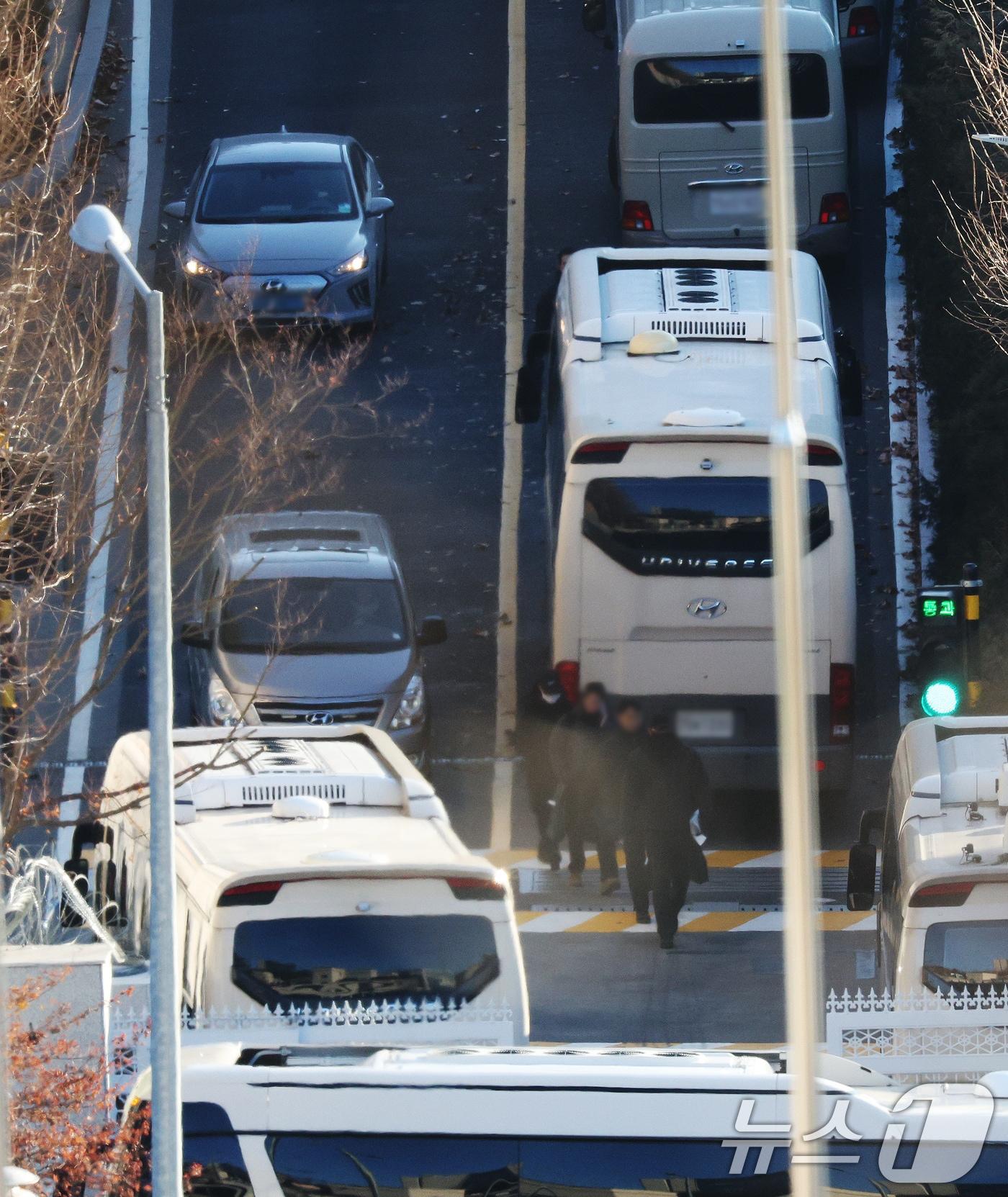 내란수괴 혐의를 받는 윤석열 대통령에 대한 체포영장이 재발부된 가운데 9일 오전 서울 용산구 한남동 대통령 관저에서 차벽을 세우기 위해 동원된 버스 차량 옆으로 경호처 등 관계자들이 이동하고 있다. 2025.1.9/뉴스1 ⓒ News1 장수영 기자