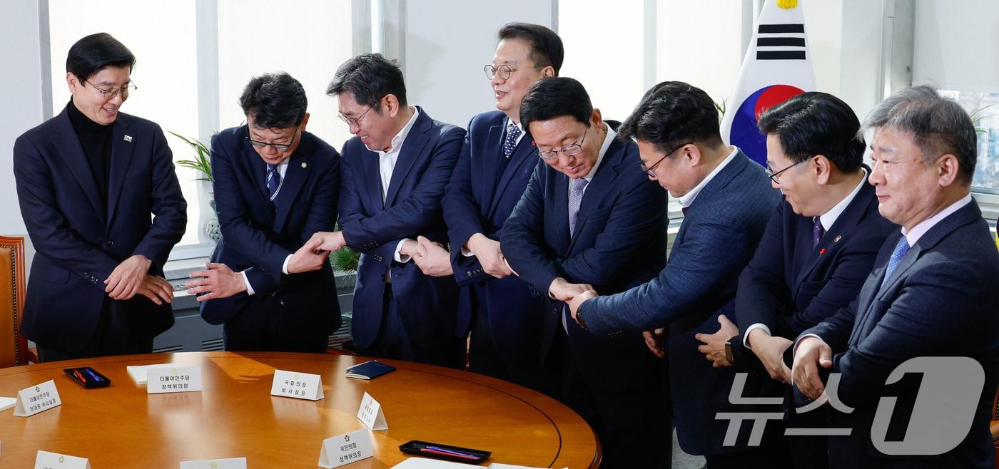 9일 서울 여의도 국회에서 ‘국회·정부 국정협의체’ 실무협의에 앞서 참석자들이 기념 촬영을 위해 손을 맞잡고 있다. 왼쪽부터 더불어민주당 이해식 당대표 비서실장, 진성준 정책위의장, 조오섭 국회의장 비서실장, 방기선 국무조정실장, 국민의힘 김상훈 정책위의장, 강명구 비상대책위원장 비서실장, 김범석 기획재정부 1차관, 곽현 국회의장 정무수석. 2025.1.9/뉴스1 ⓒ News1 안은나 기자