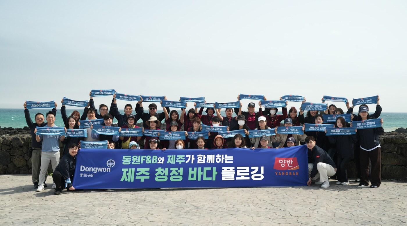 18일 서귀포시 표선면에서 진행된 ‘제주 청정 바다 플로깅’ 행사에서 동원F&B 직원들이 기념 사진 촬영을 하고 있다.(동원F&B 제공)