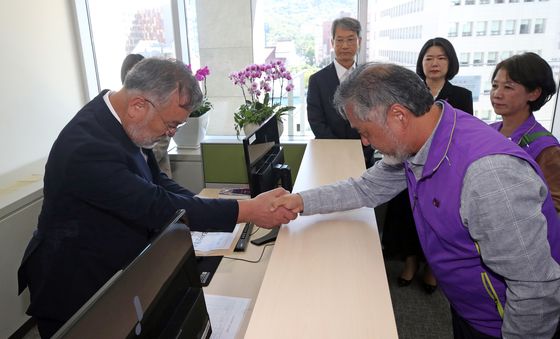 악수하는 송기춘 특조위 위원장과 이정민 이태원 참사 유가족협의회 위원장