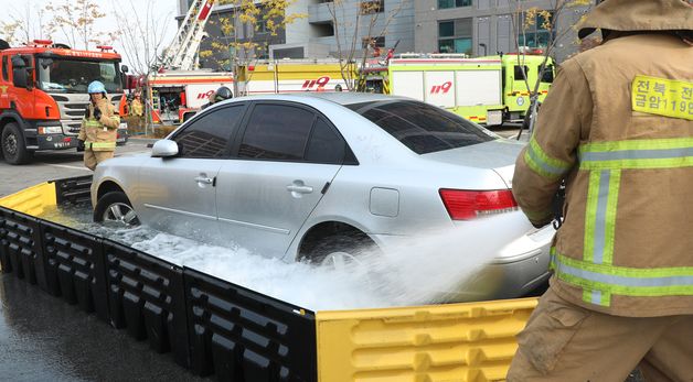 이동식 침수조 활용한 전기차 화재 진압 훈련하는 소방관들