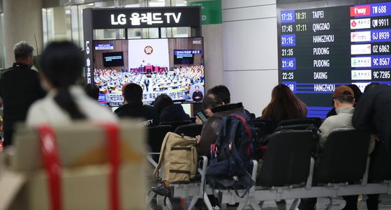 탄핵안 표결 생중계 시청하는 제주공항 관광객들