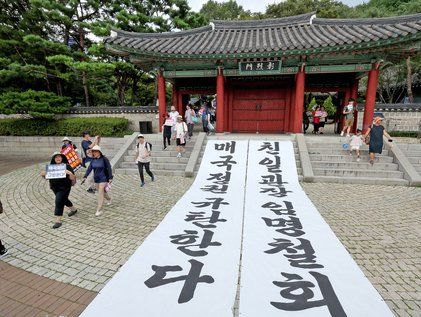 정권 규탄 대형 현수막 앞 행진하는 시민단체 관계자들