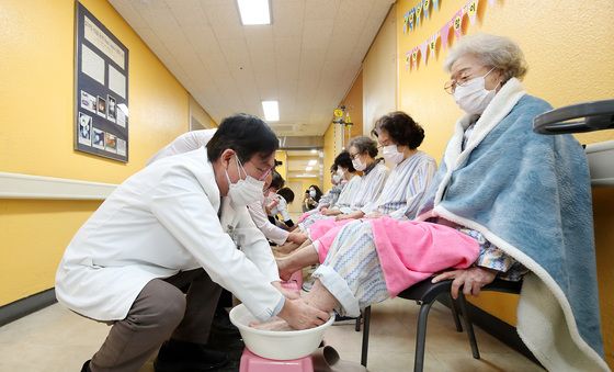 환자 발 씻겨주는 곽병원 의료진