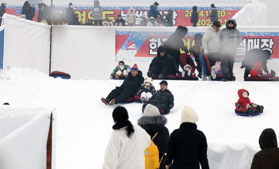 눈 내리는 서울 도심…북적이는 눈썰매장